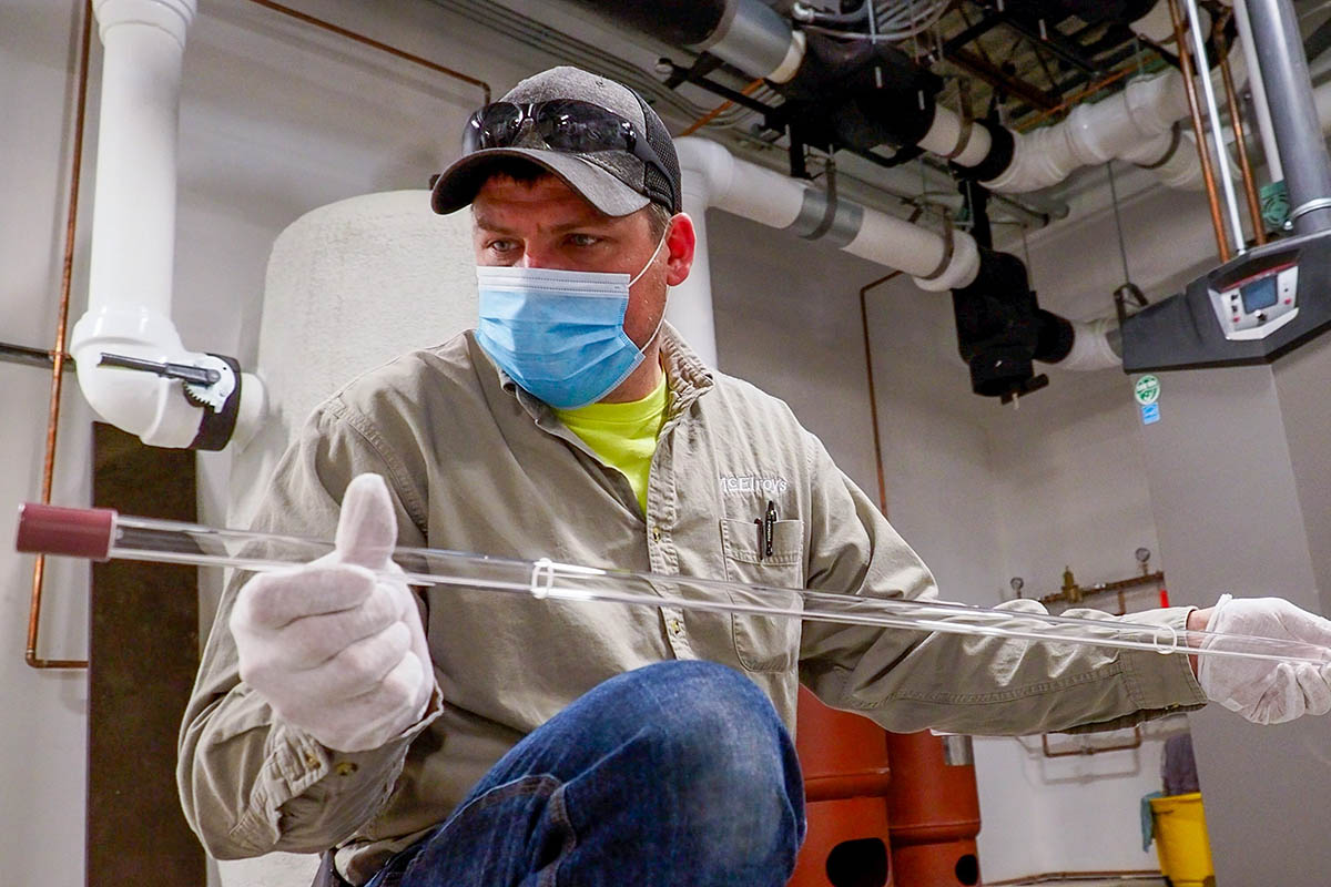 McElroy’s commercial construction project supervisor, Preston Bond, prepares a UVC air-sterilization bulb for installation.