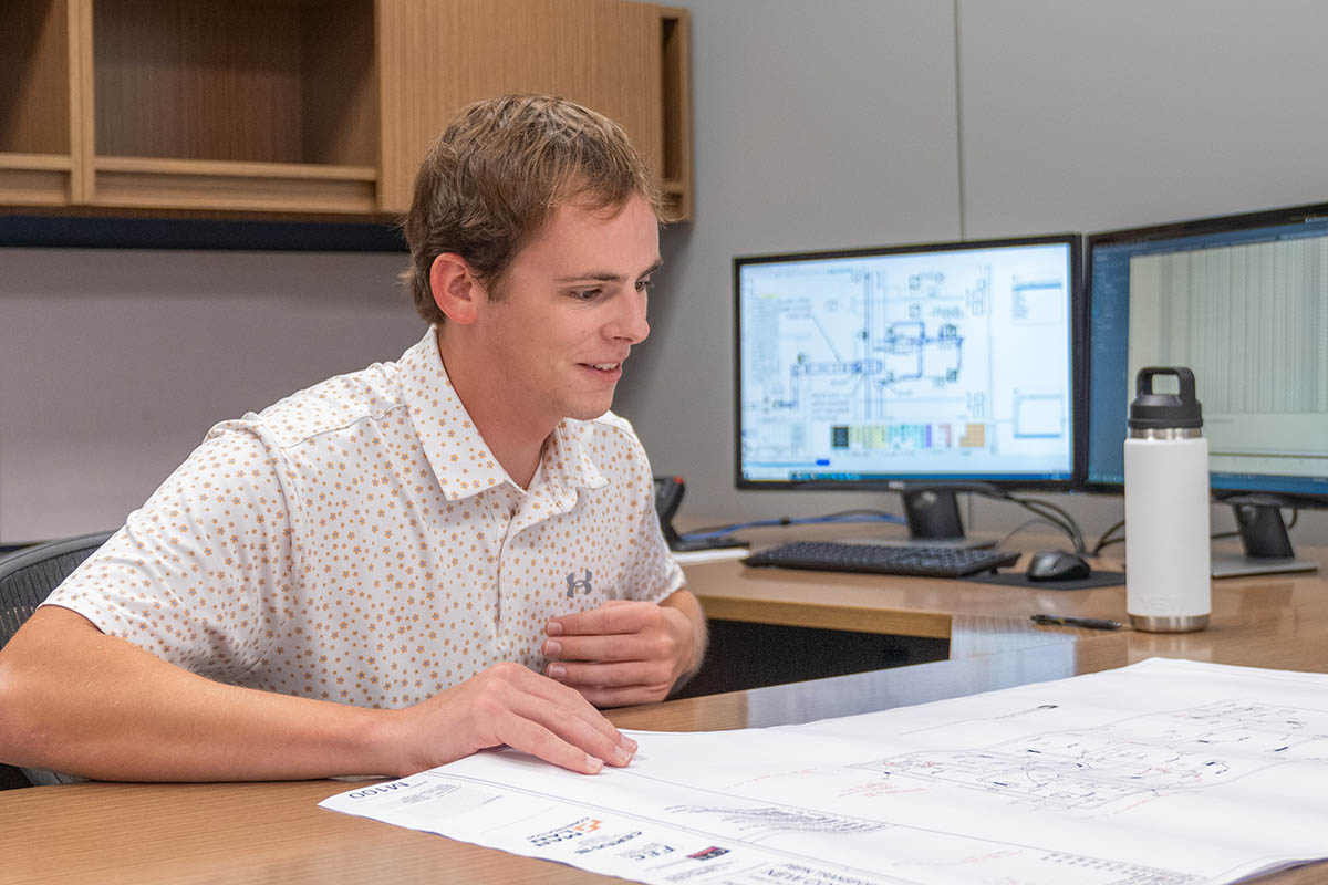 Luke Rothfuss, KU mechanical engineering student, reviews construction plans while interning at McElroy’s.