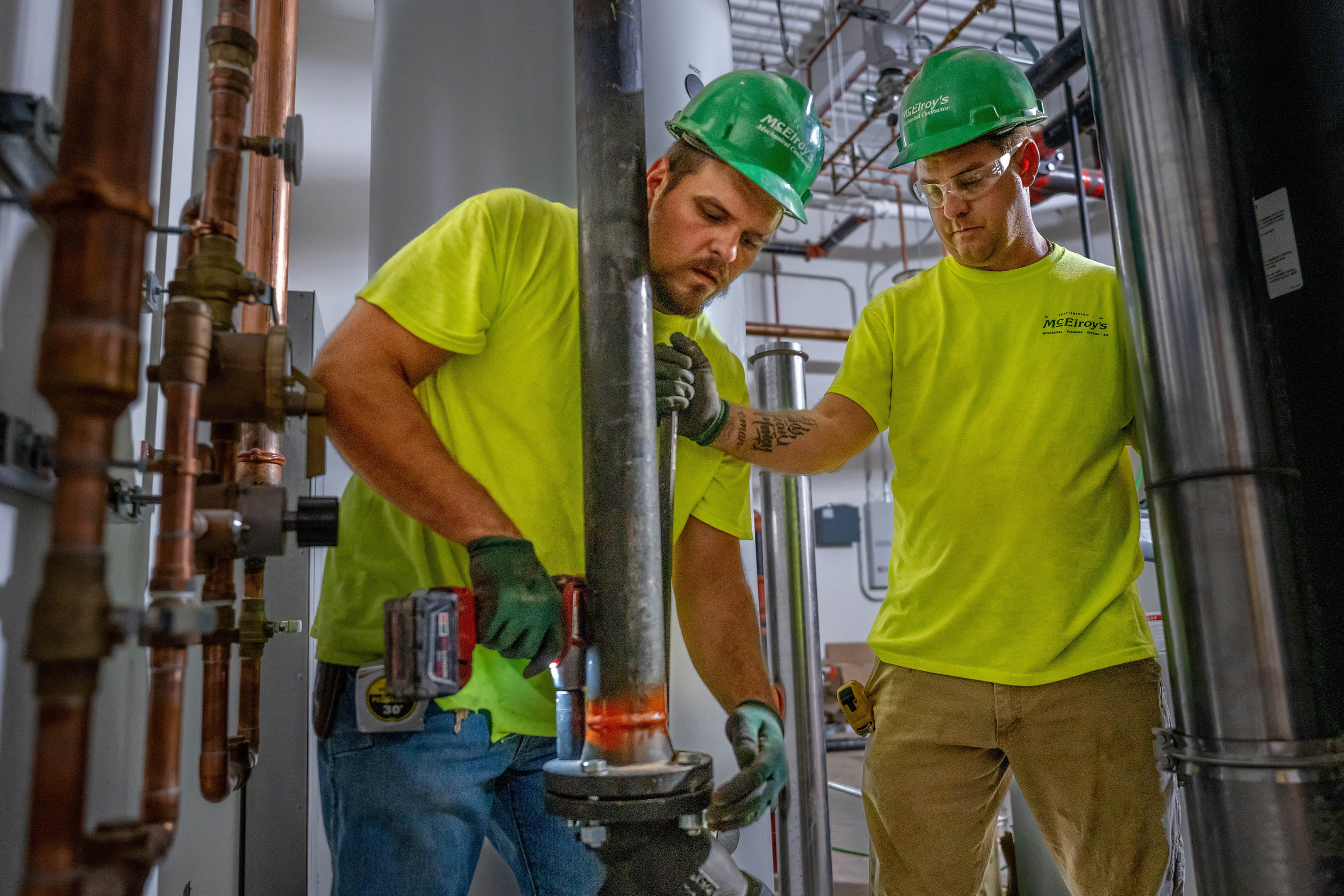 Dusty Bergquist and Levi Strathman, McElroy’s commercial construction pipefitters, work together to secure piping.