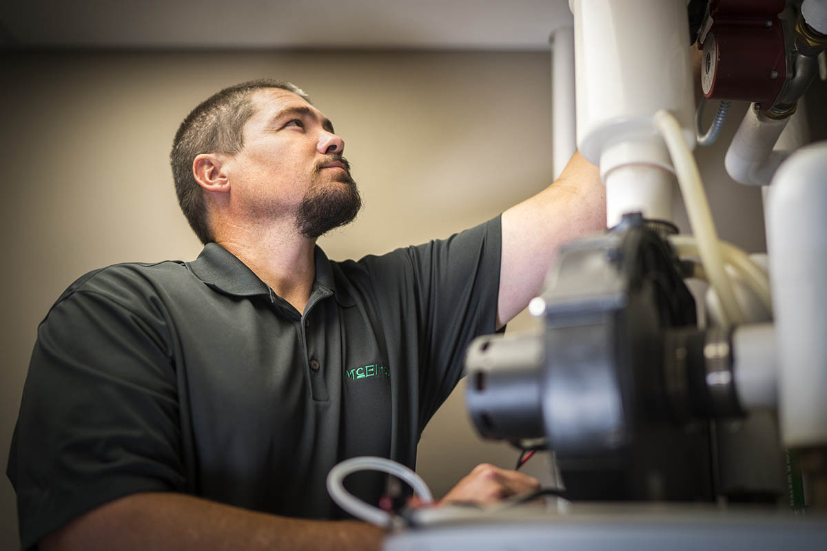 Luke Dumler, McElroy’s plumbing service manager, works on a commercial water heating system.