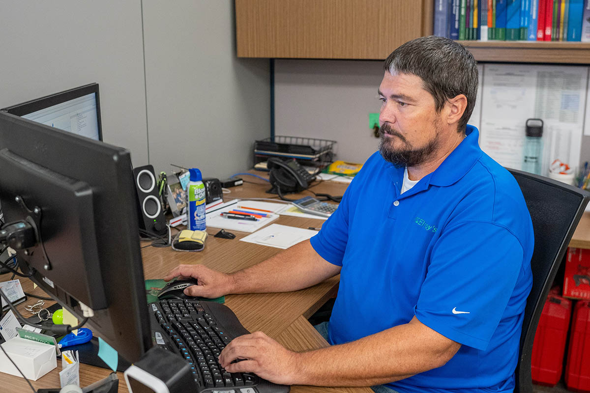 Luke Dumler, works at his computer to manage the McElroy’s plumbing service department.